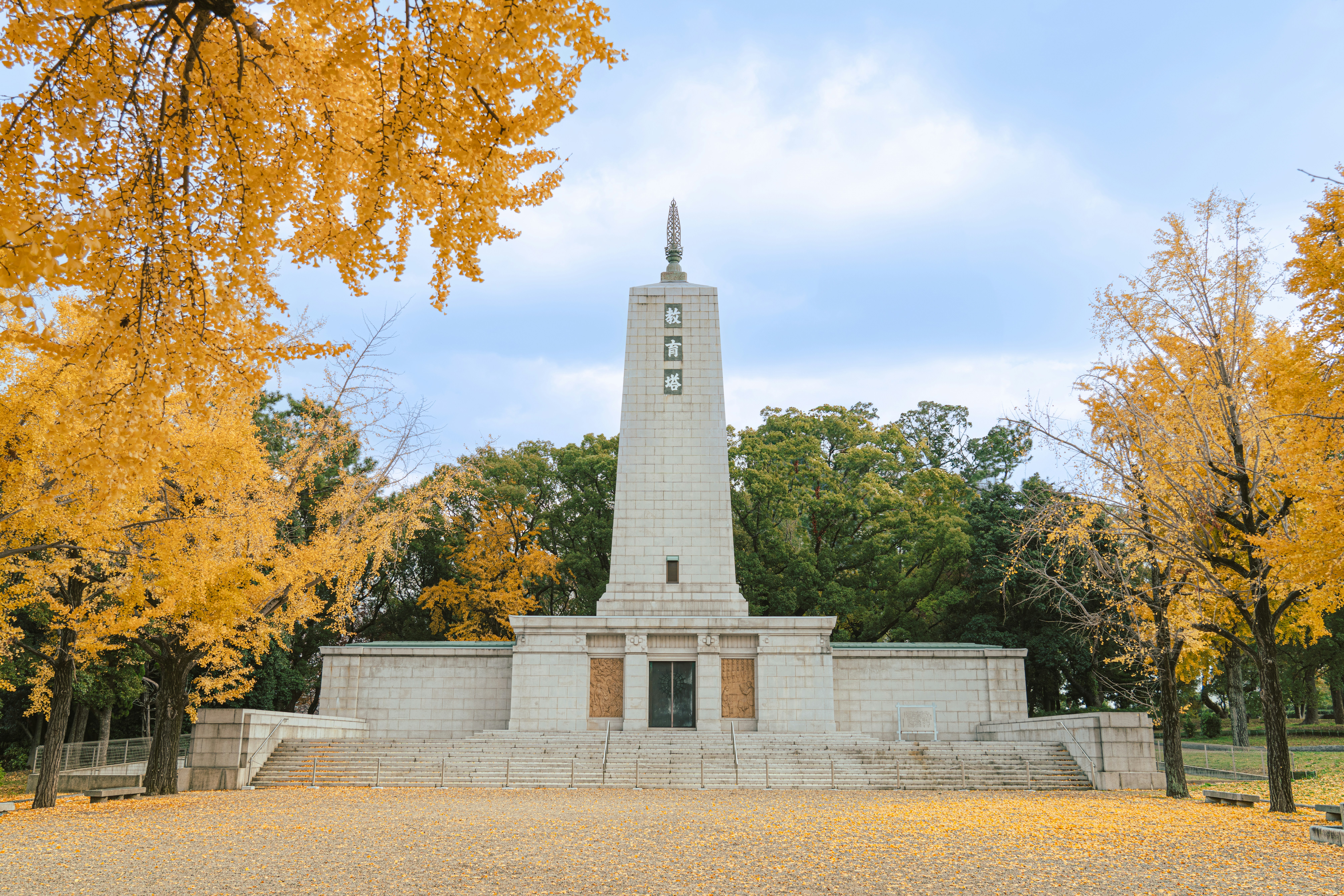 a monument in the middle of a park surrounded by trees