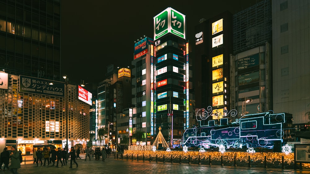 a city street at night with people walking around