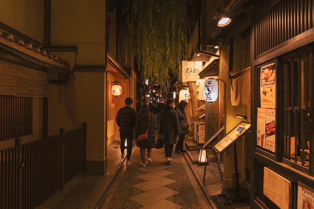 a group of people walking down a street at night