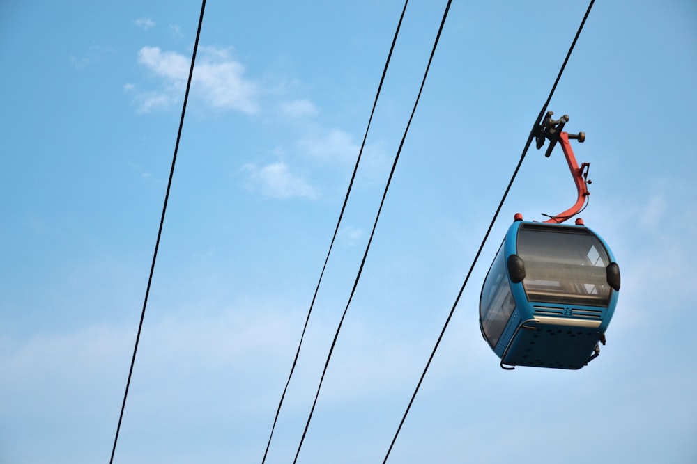 a blue cable car with a sky background