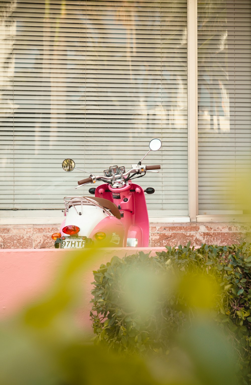 a red scooter parked in front of a window