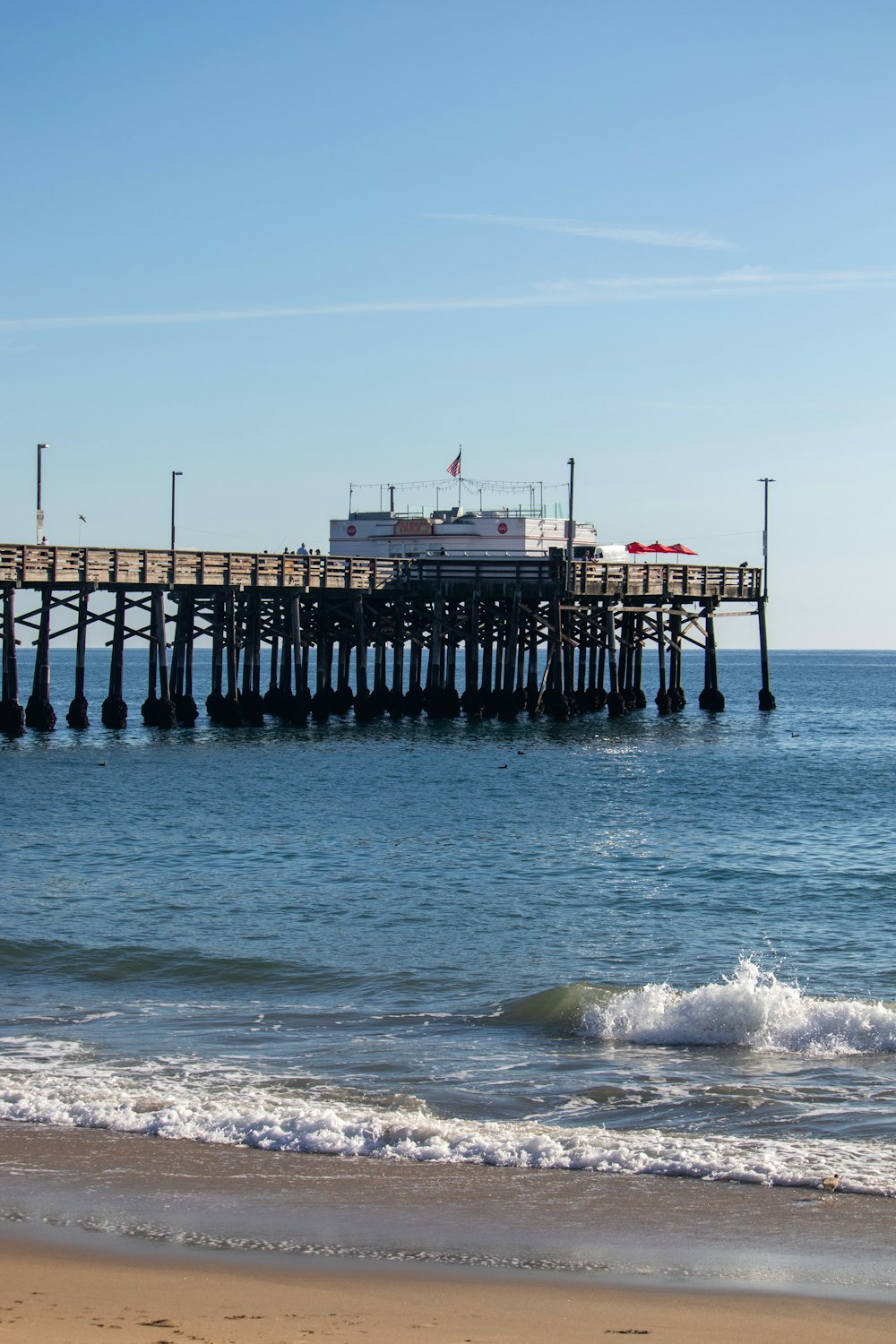 a pier on the beach with waves coming in