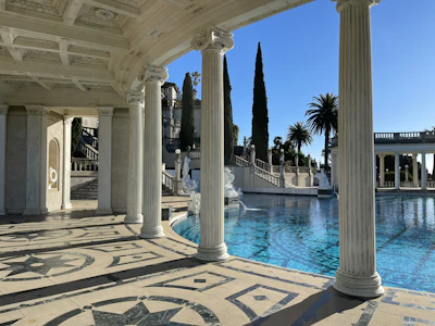 a pool surrounded by columns and a fountain