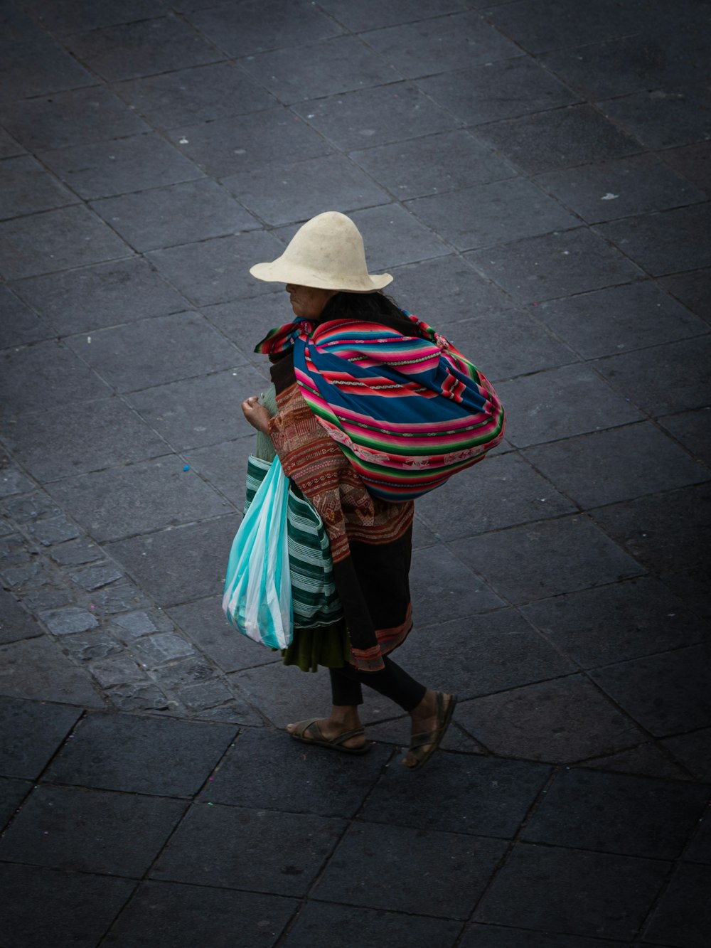 a woman walking down a street carrying bags