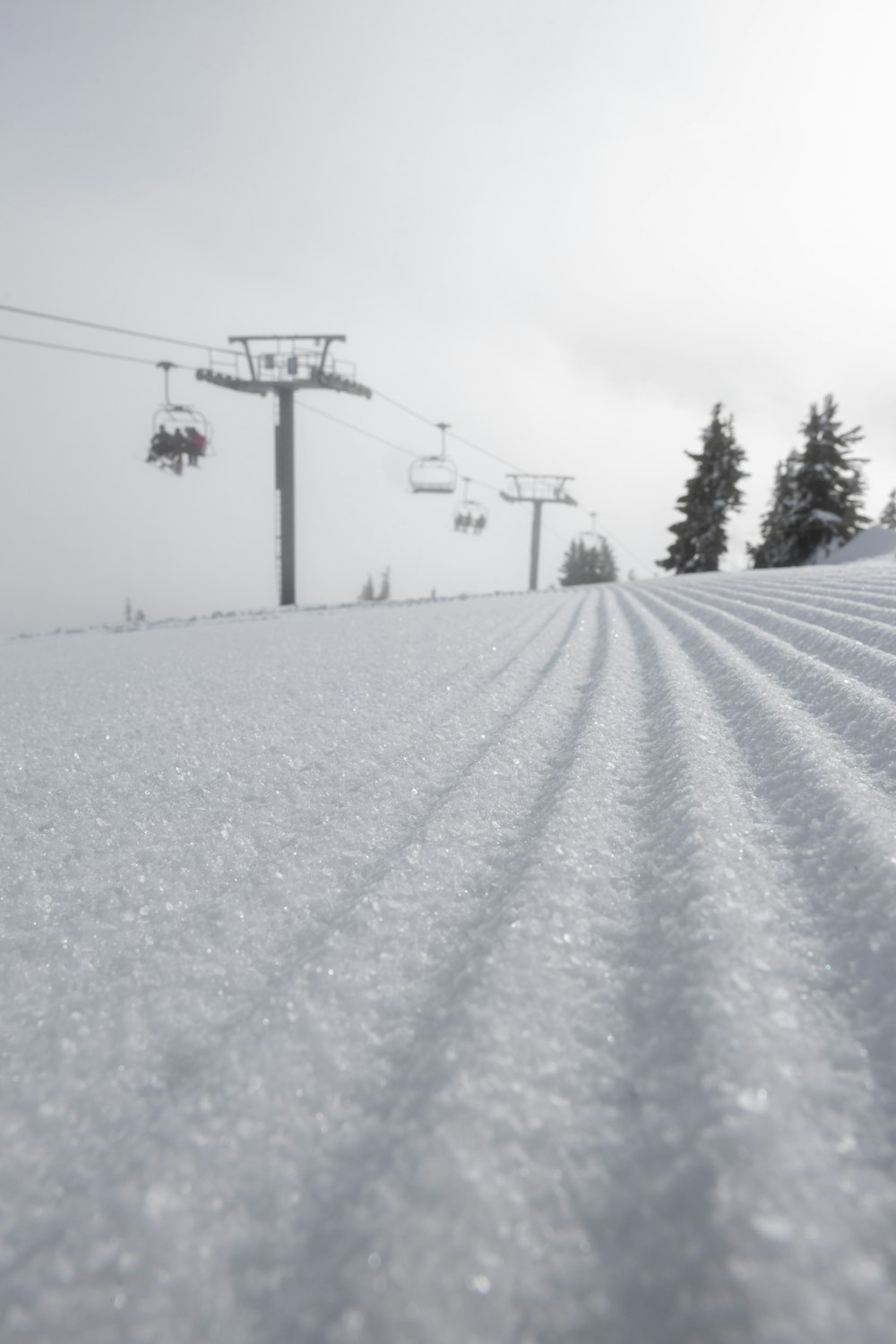 a snow covered ski slope with a ski lift in the background