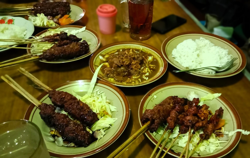 a table topped with plates of food and chopsticks