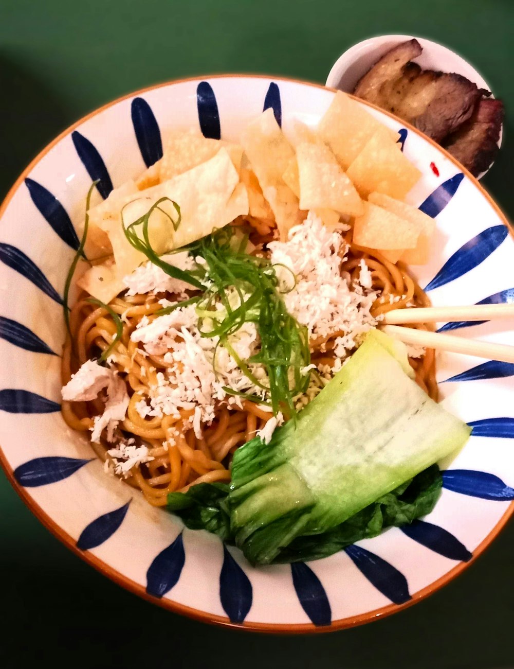 a bowl of food with chopsticks in it