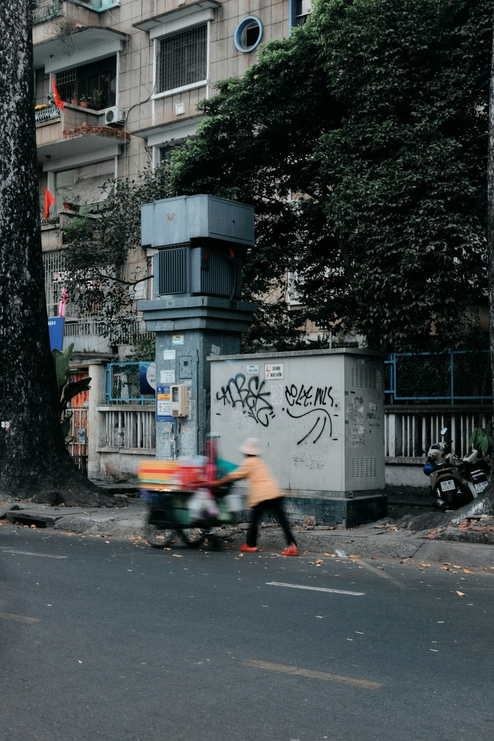 two people pushing a cart down a street