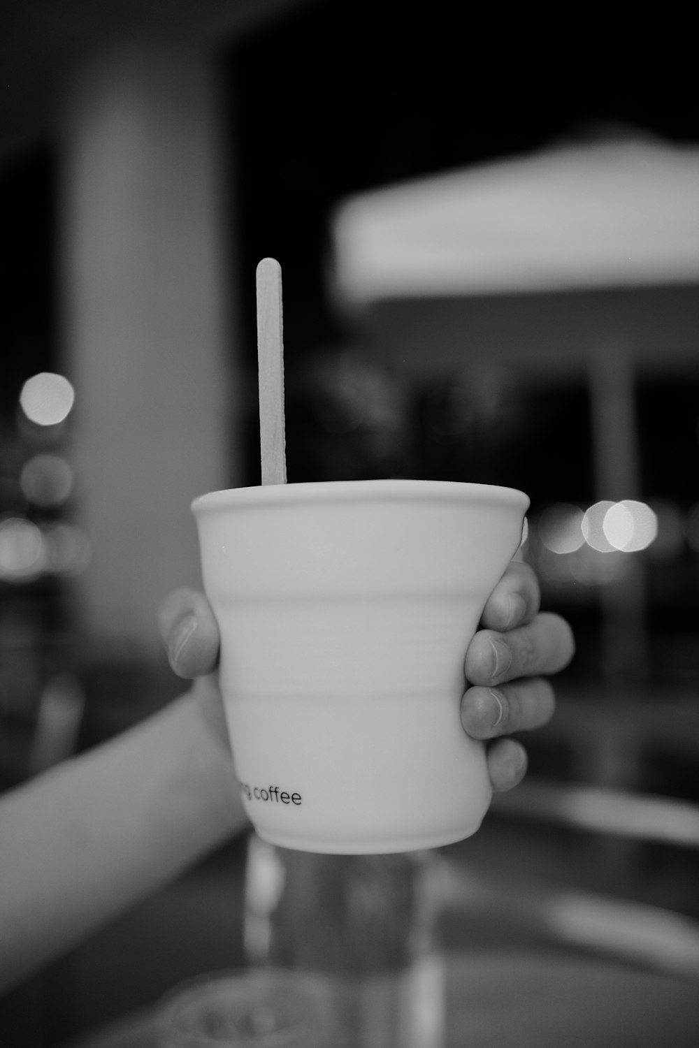 a person holding a cup with a straw in it