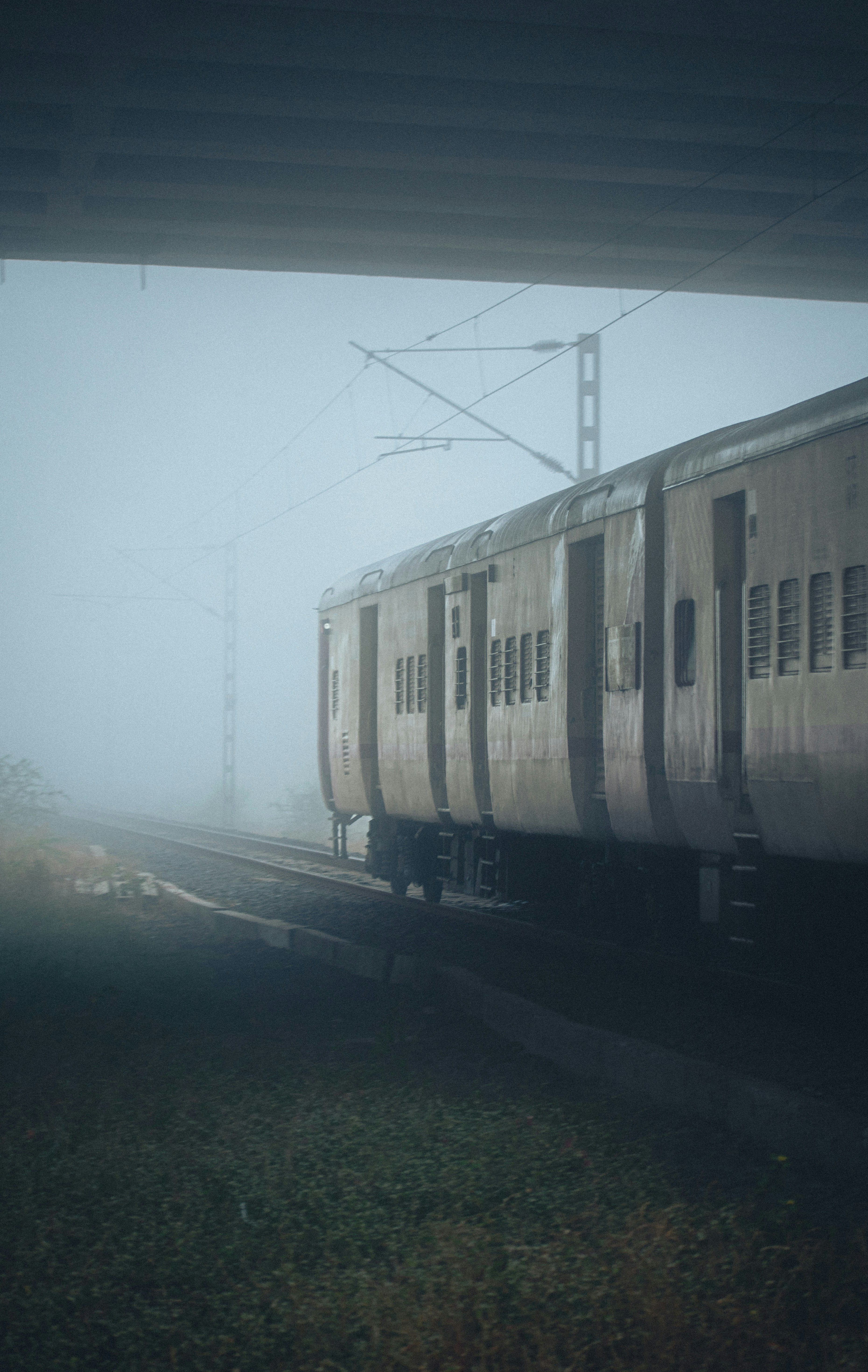 a train traveling down train tracks in the fog