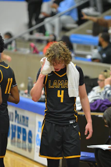 a basketball player wiping his face with a towel