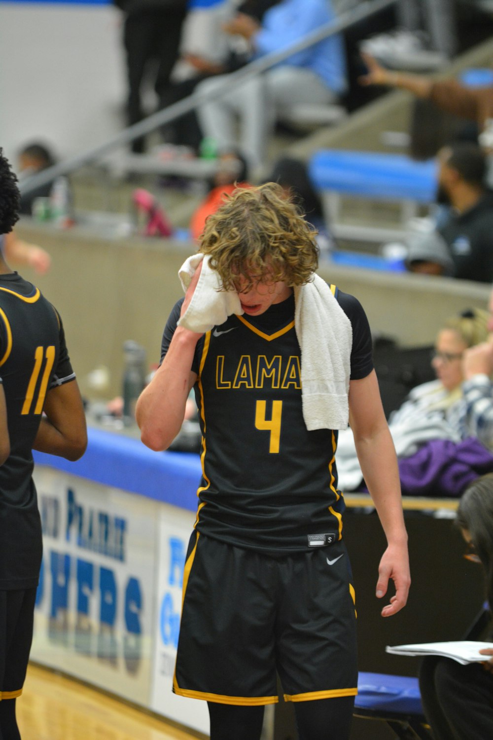 a basketball player wiping his face with a towel