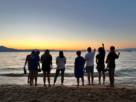 a group of people standing on top of a sandy beach