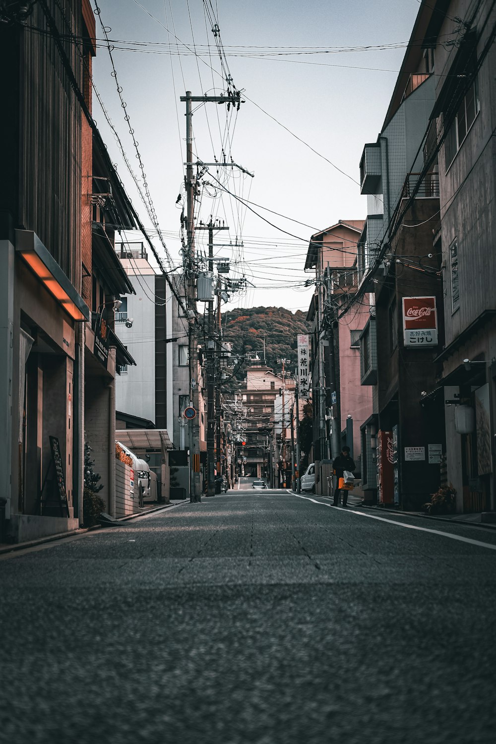 an empty street in a city with power lines above it