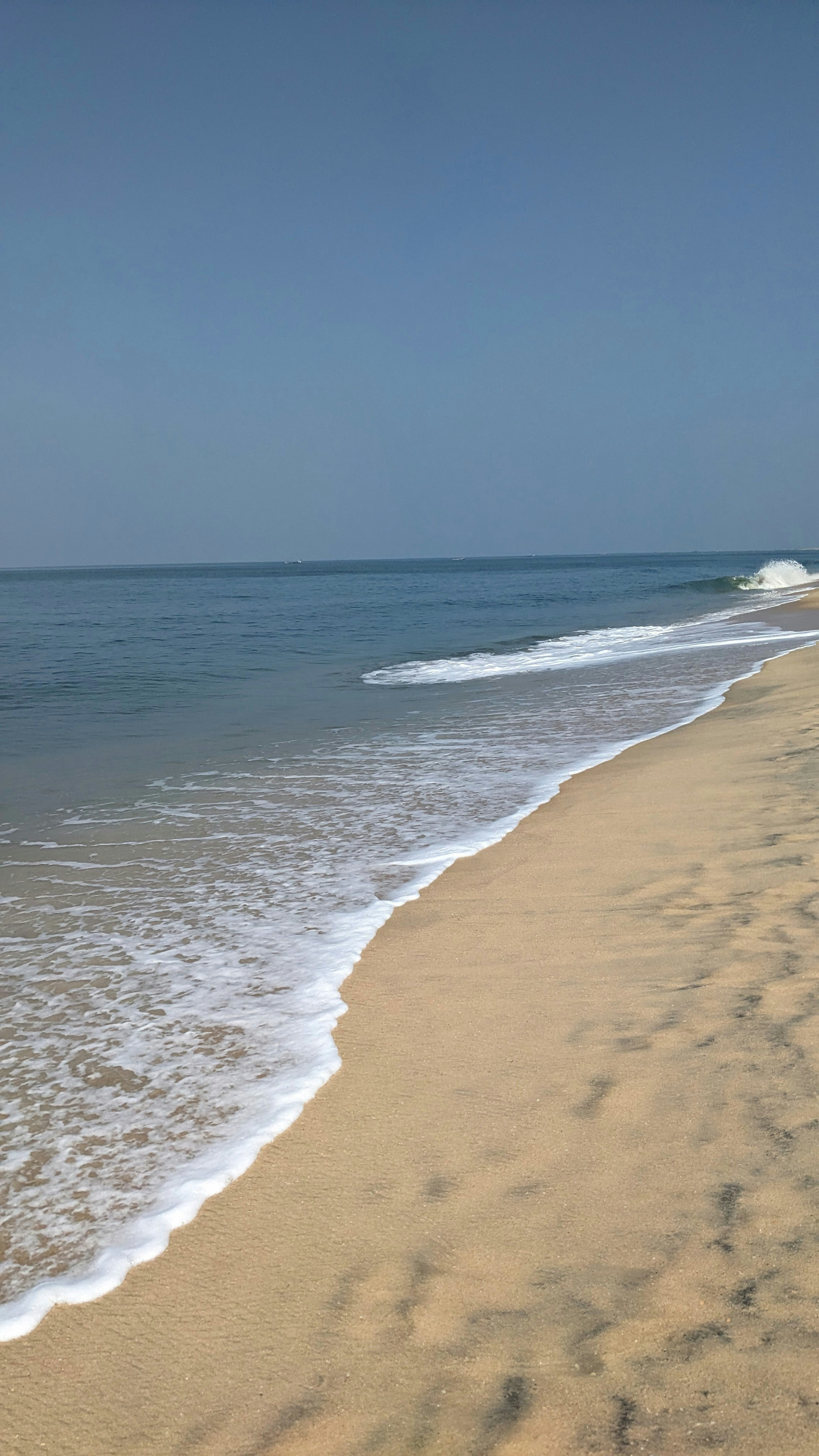 a sandy beach with waves coming in to shore