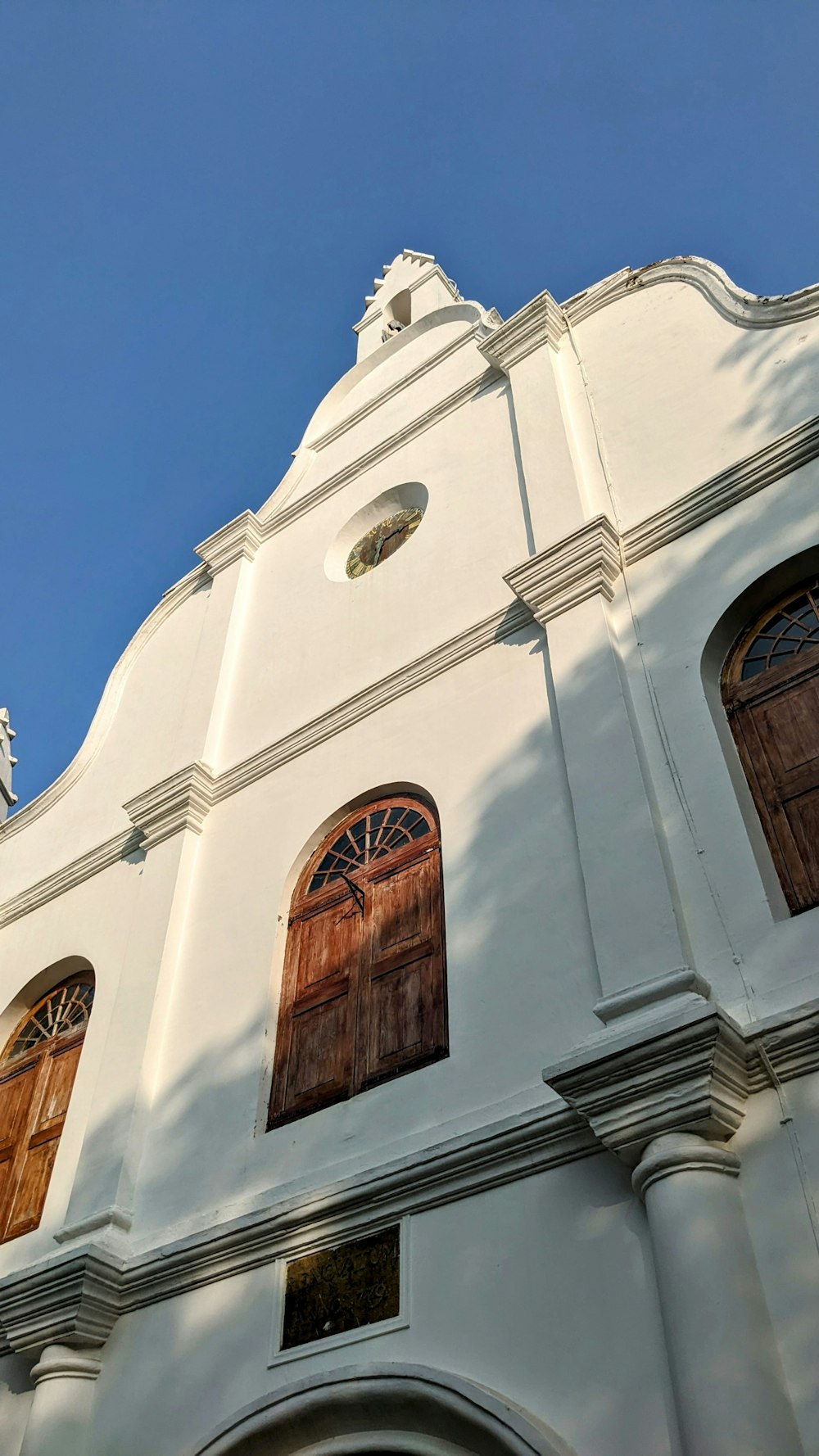 a white building with wooden doors and a clock tower