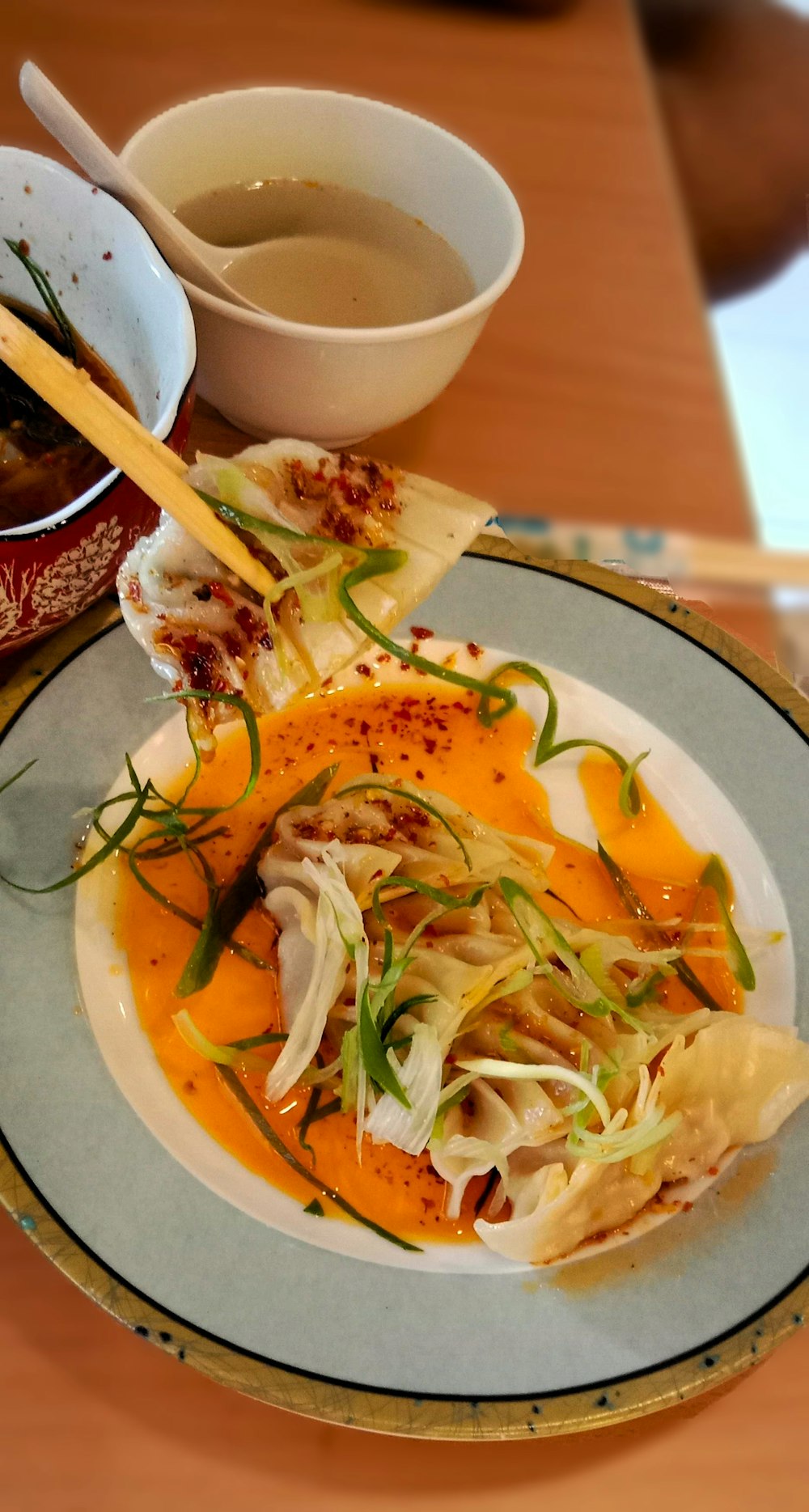 a plate of food on a table with a bowl of soup