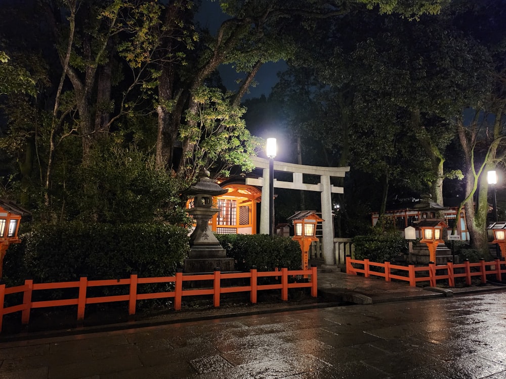 a japanese shrine lit up at night in the rain