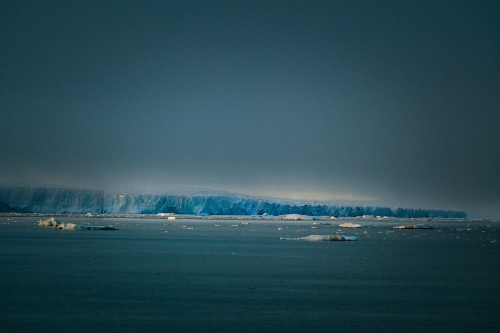 a group of icebergs floating on top of a body of water