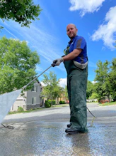 a man is cleaning the street with a hose