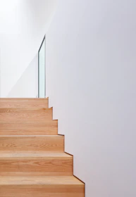 a wooden stair case with glass railing