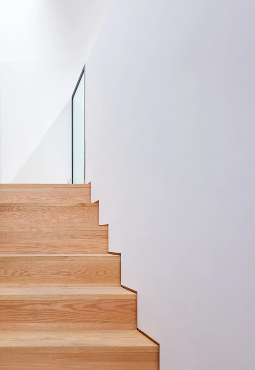 a wooden stair case with glass railing
