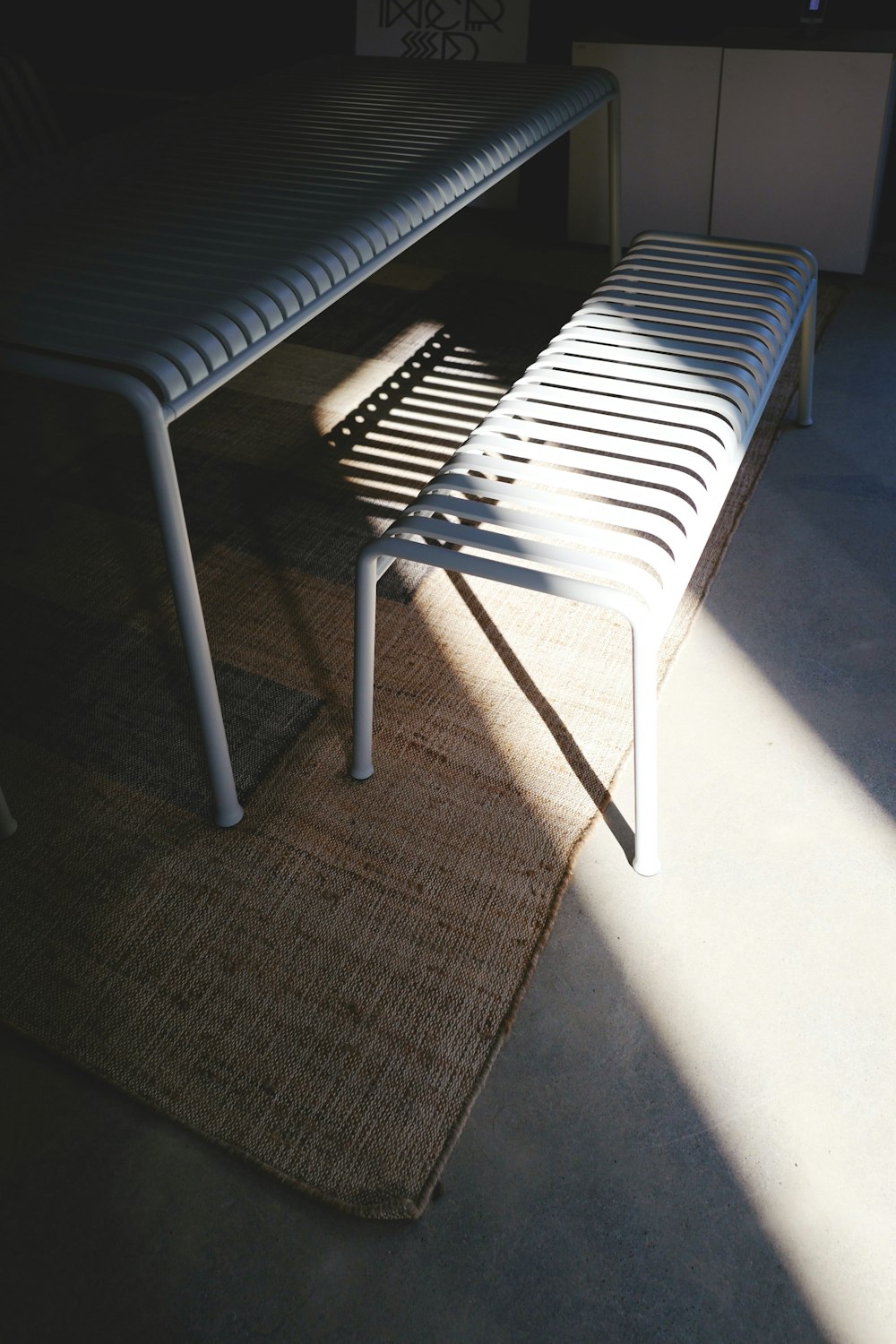 a bench sitting on top of a rug next to a window