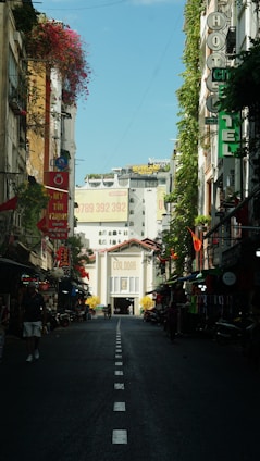 a narrow street with buildings and signs on both sides