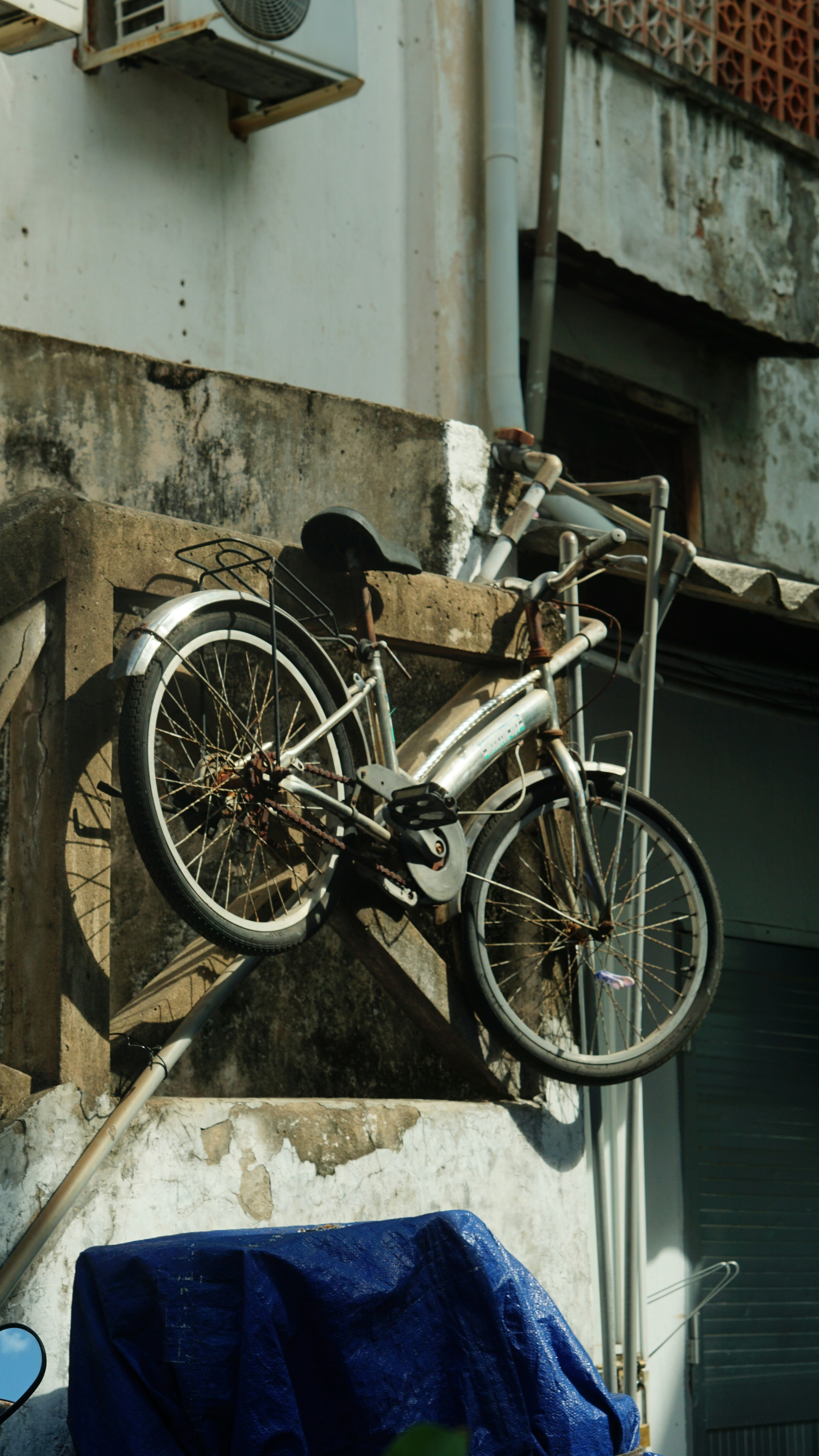 a bicycle hanging from the side of a building