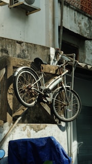 a bicycle hanging from the side of a building