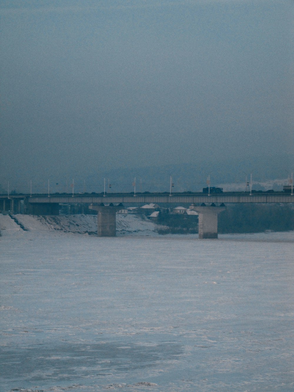 a large body of water with a bridge in the background