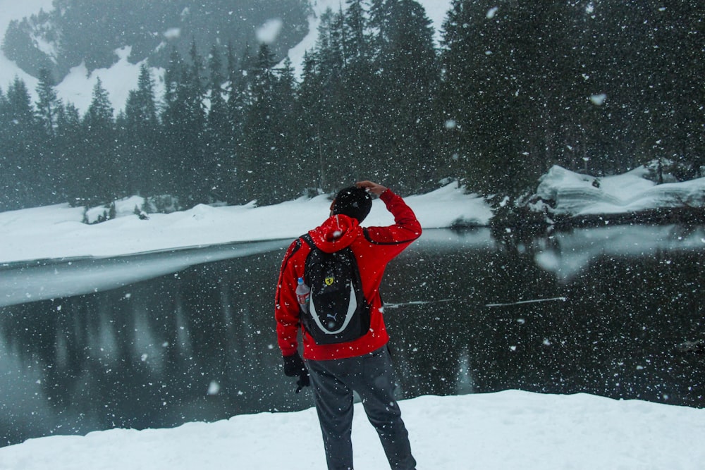 a man in a red jacket standing in the snow