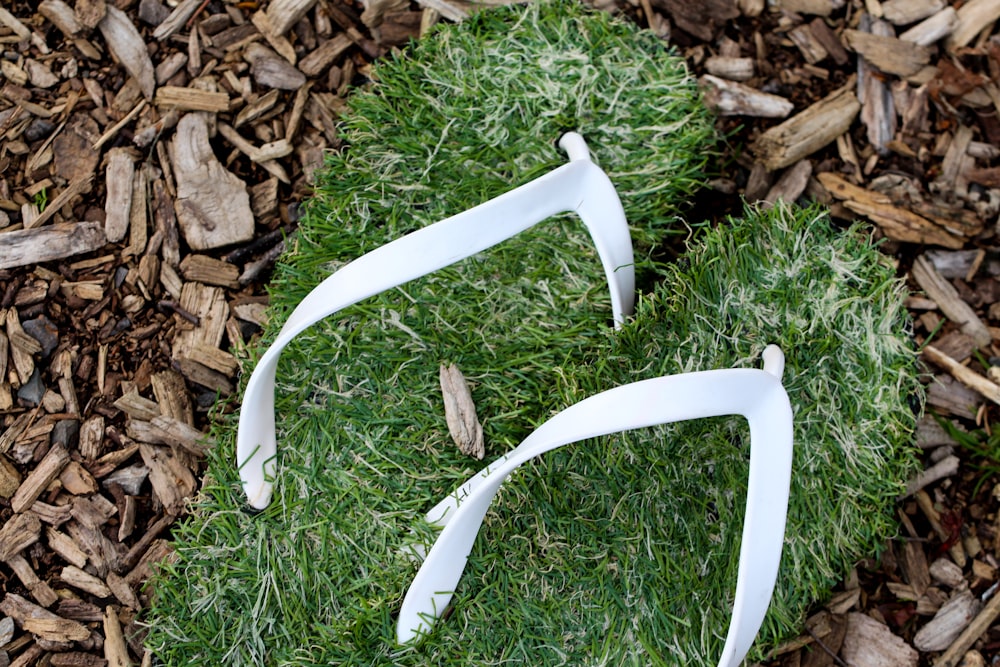 a pair of white glasses laying on top of green grass