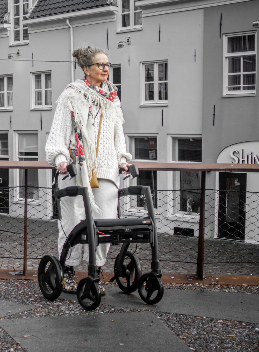 an older woman standing next to a walker