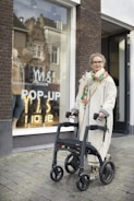 a woman standing next to a stroller in front of a store