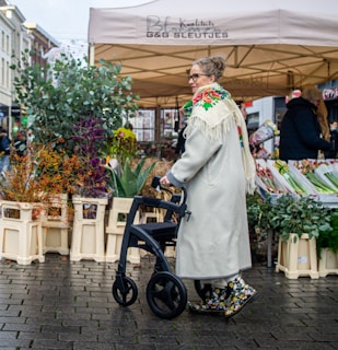a woman pushing a stroller through an outdoor market