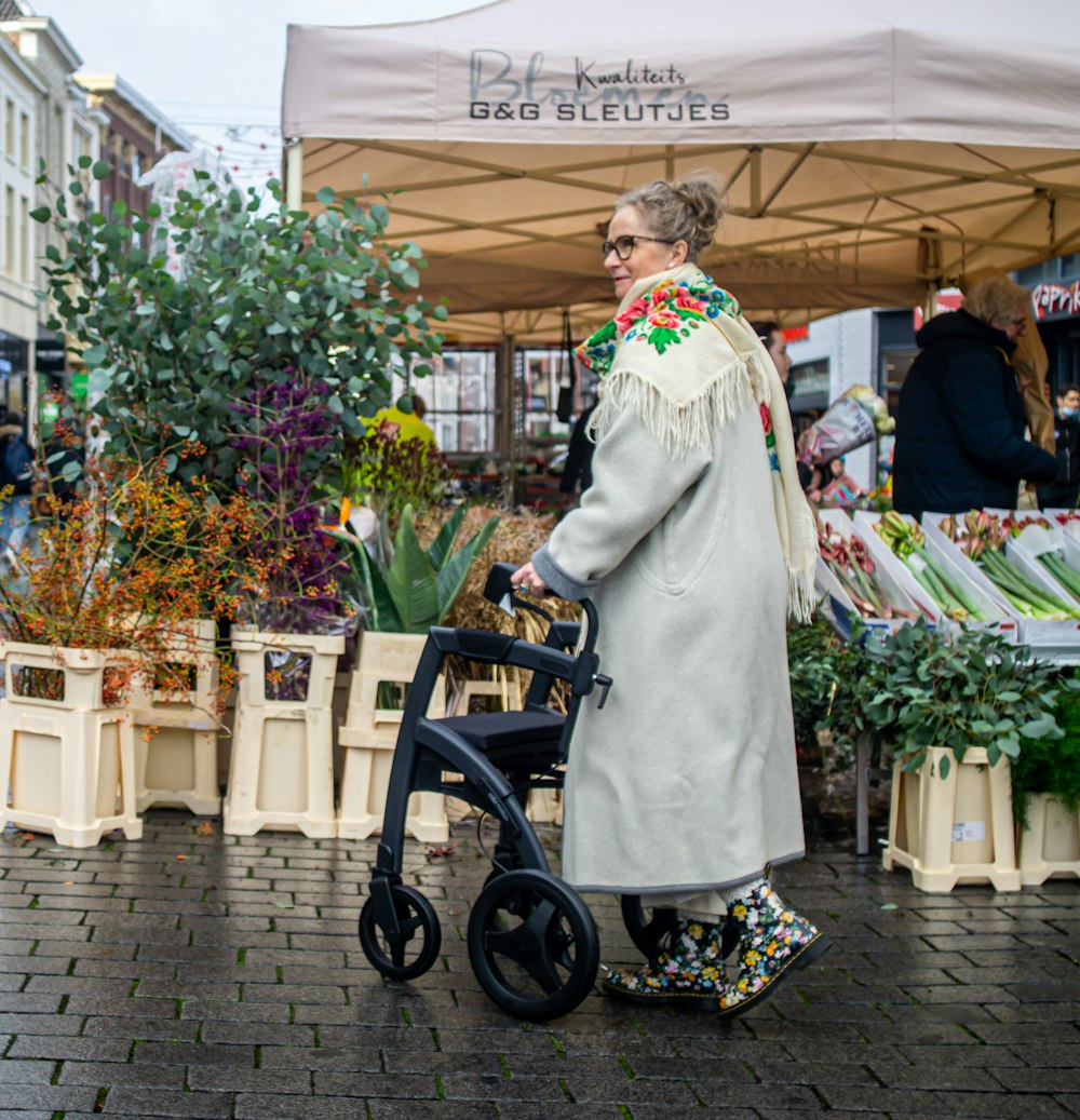 a woman pushing a stroller through an outdoor market