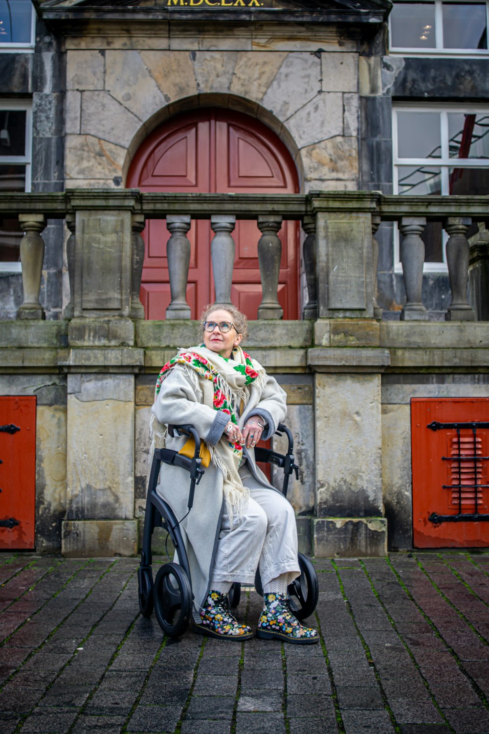 a woman sitting in a chair in front of a building