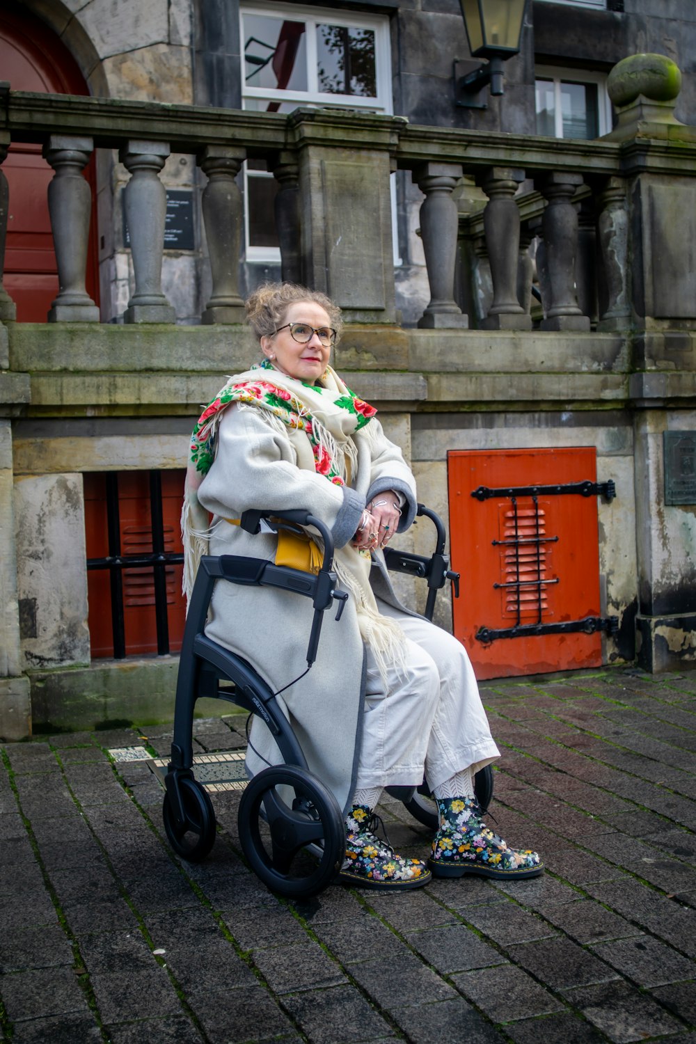 a woman sitting on a chair in front of a building