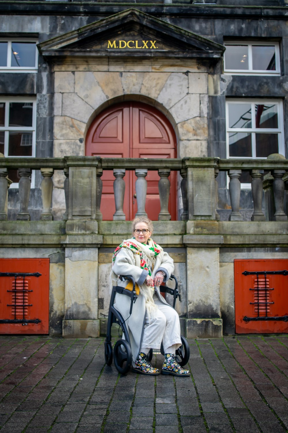 a woman sitting on a scooter in front of a building