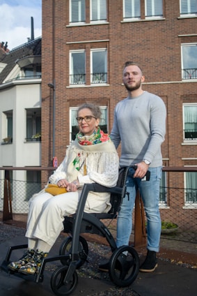 a man standing next to a woman in a wheelchair