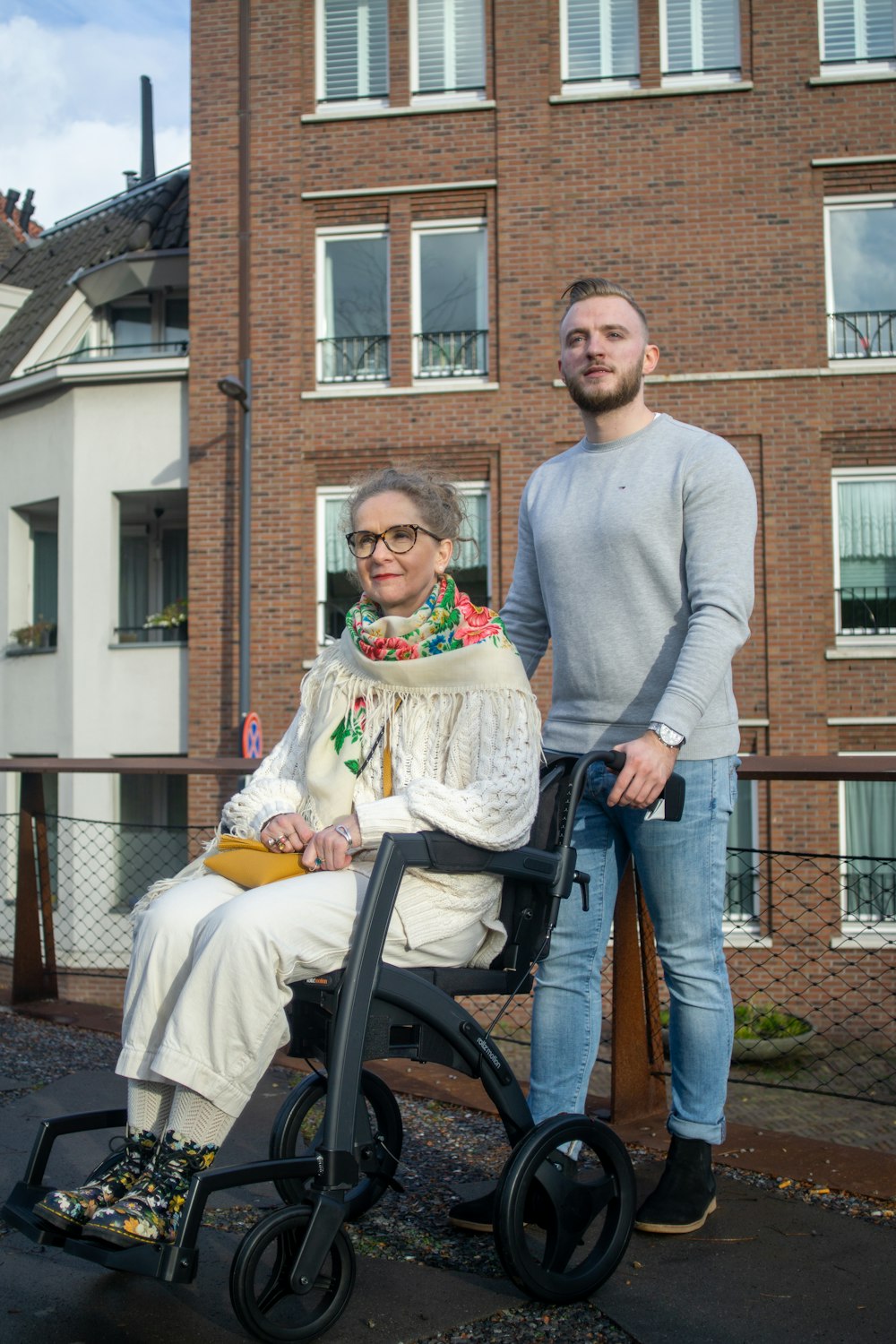 a man standing next to a woman in a wheelchair