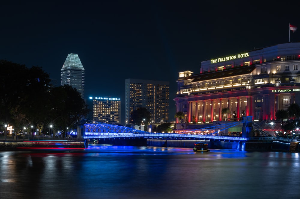 a city at night with a bridge over a river