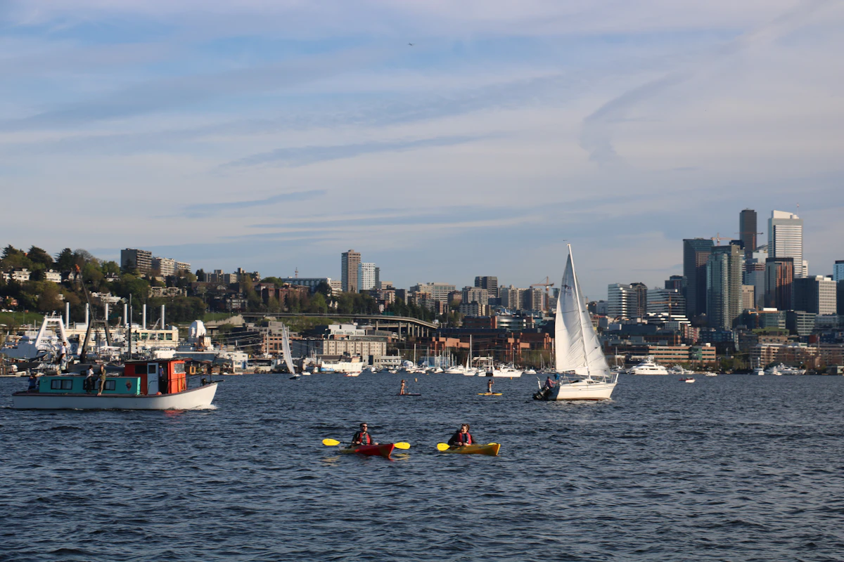 Two kayakers paddling on Lake Union with the Seattle skyline behind them