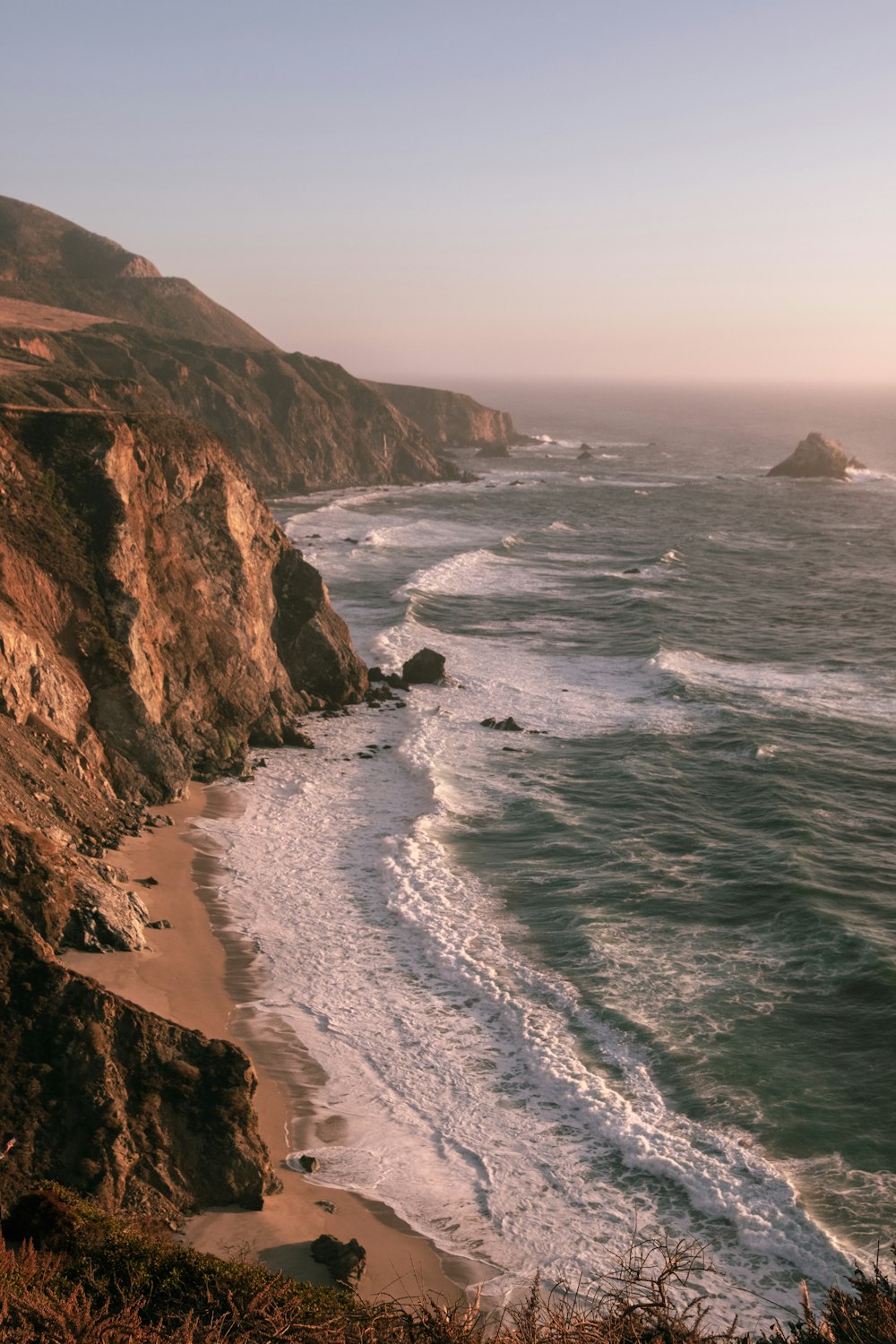 a view of the ocean from the top of a hill