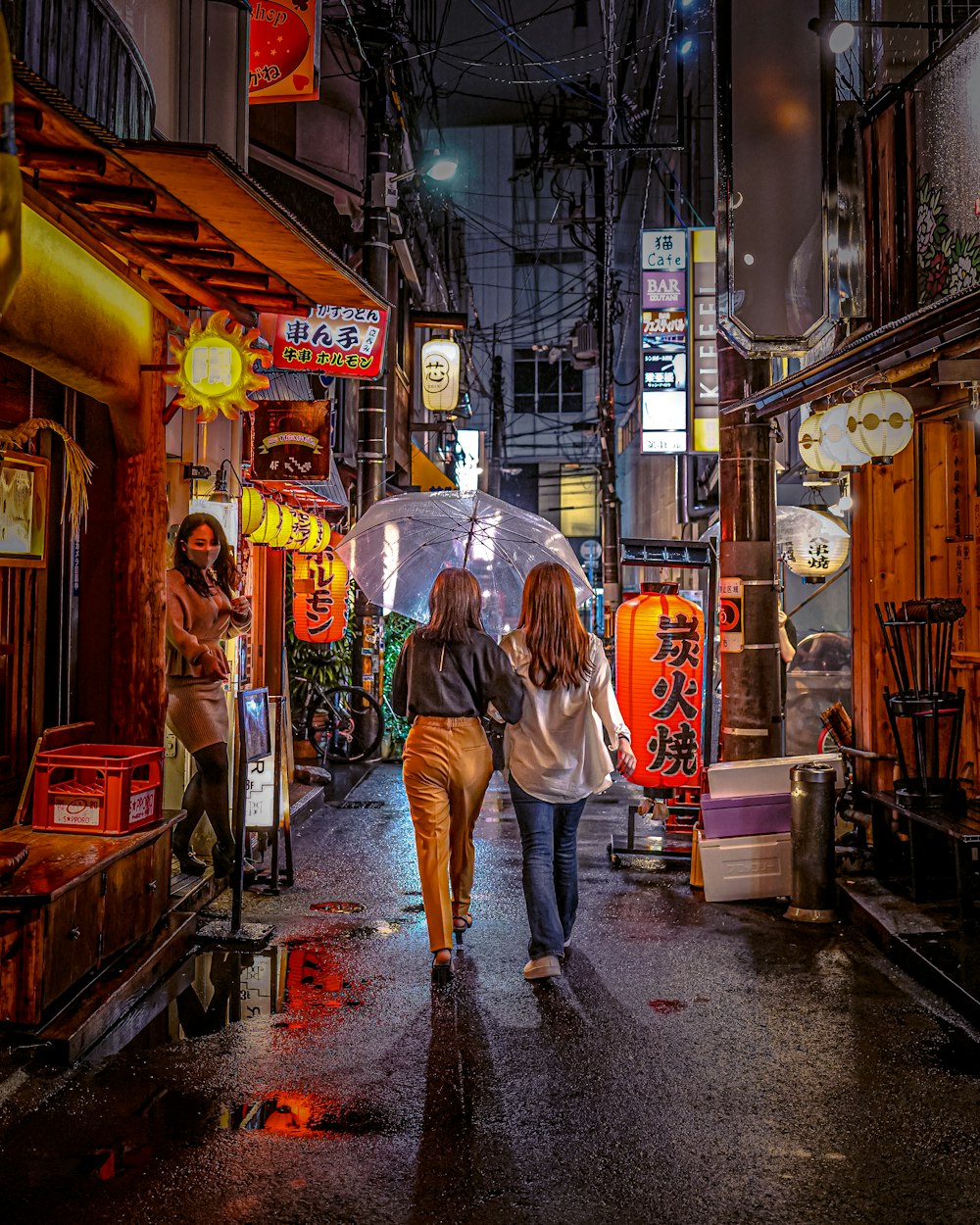 a couple of women walking down a street holding an umbrella