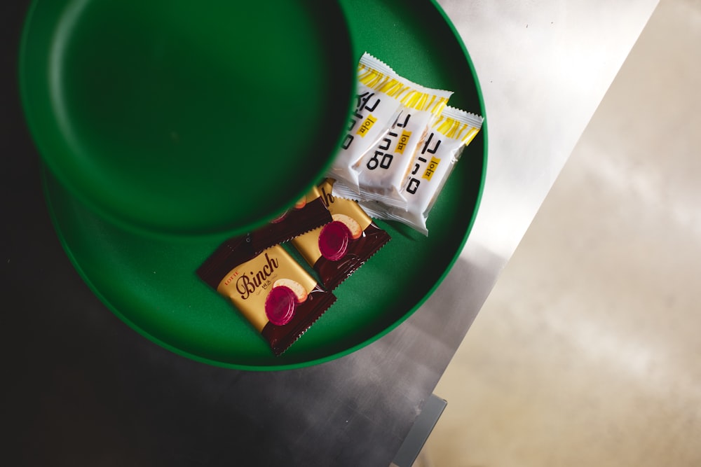 a green plate with two pieces of candy on it