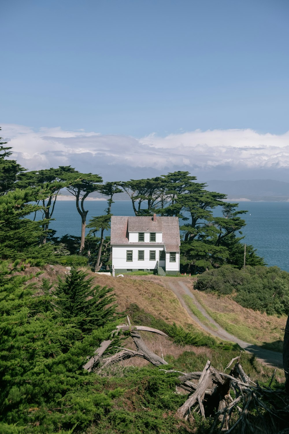 a white house sitting on top of a lush green hillside