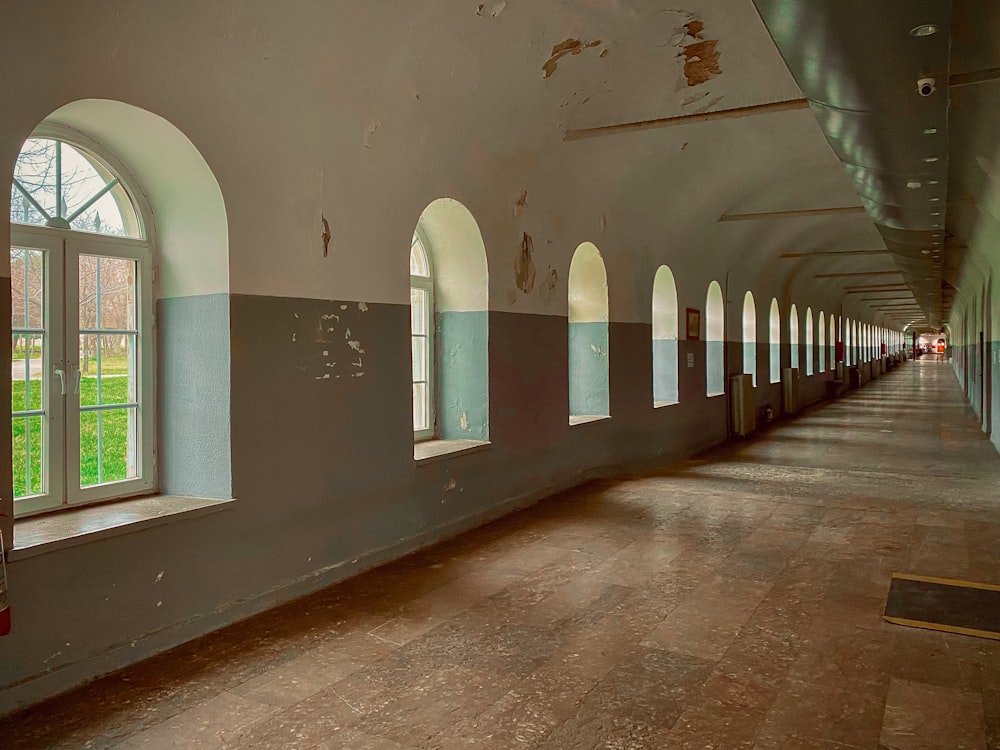 a long hallway with arched windows and a wooden floor