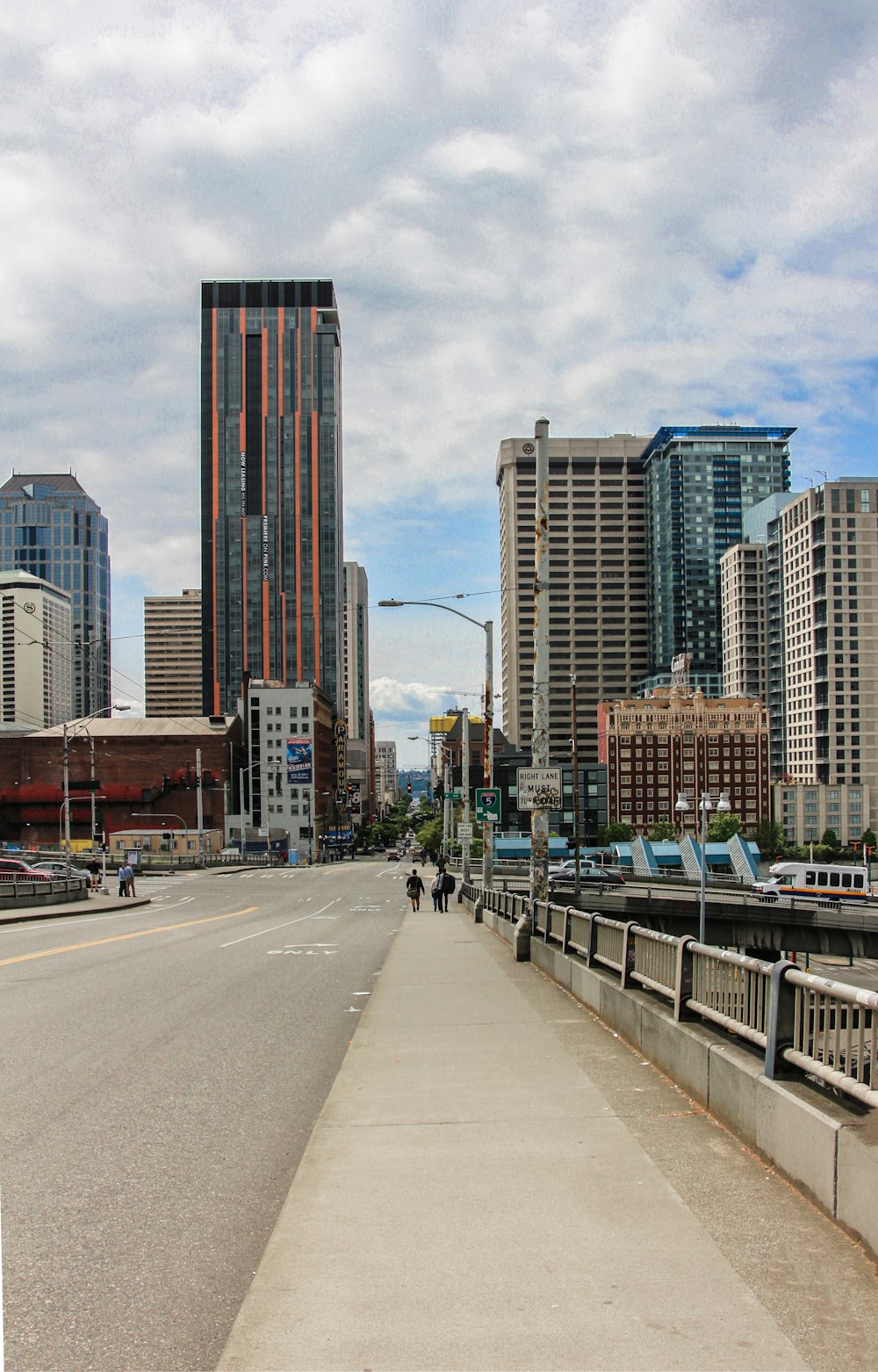 a city street lined with tall buildings under a cloudy sky